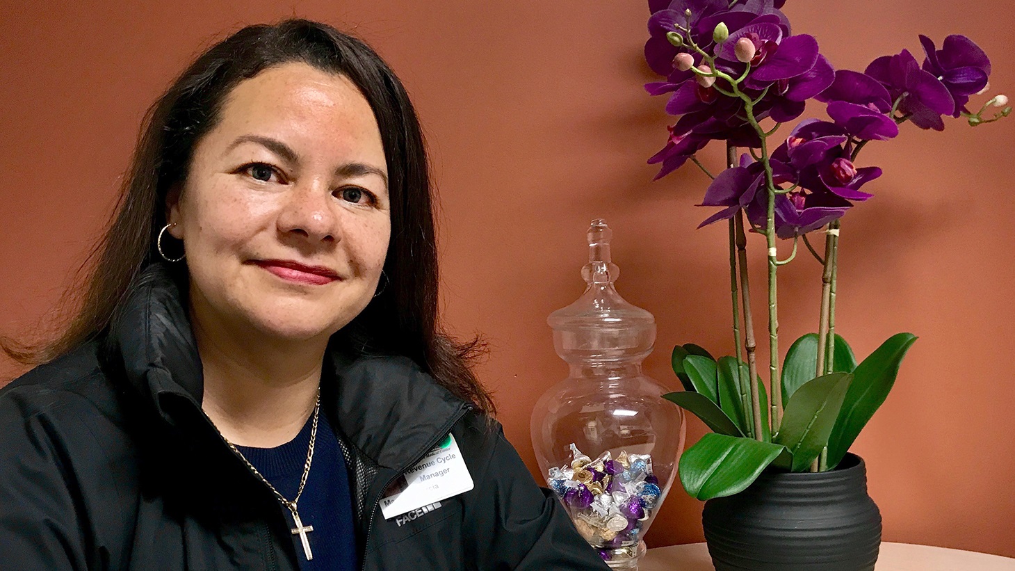 portrait of a woman, sitting next to a jar of candy and an orchid plant