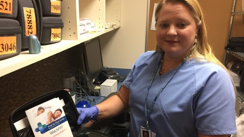 Nurse displaying sleep monitor in a case. 