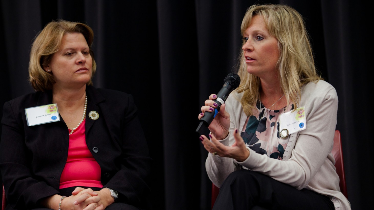 Two women (seated) speaking on a stage