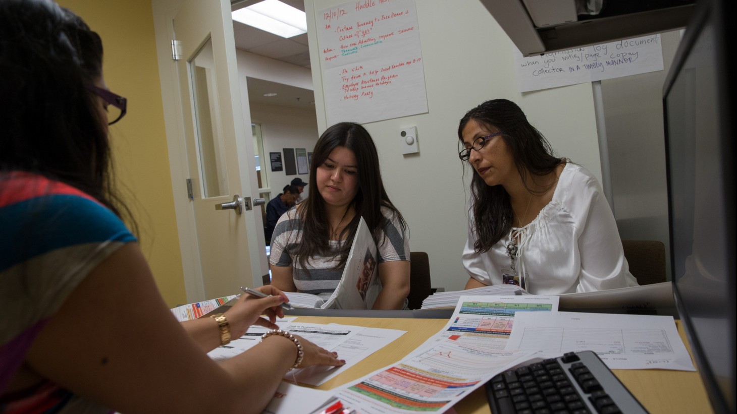 three women meeting around a desk 