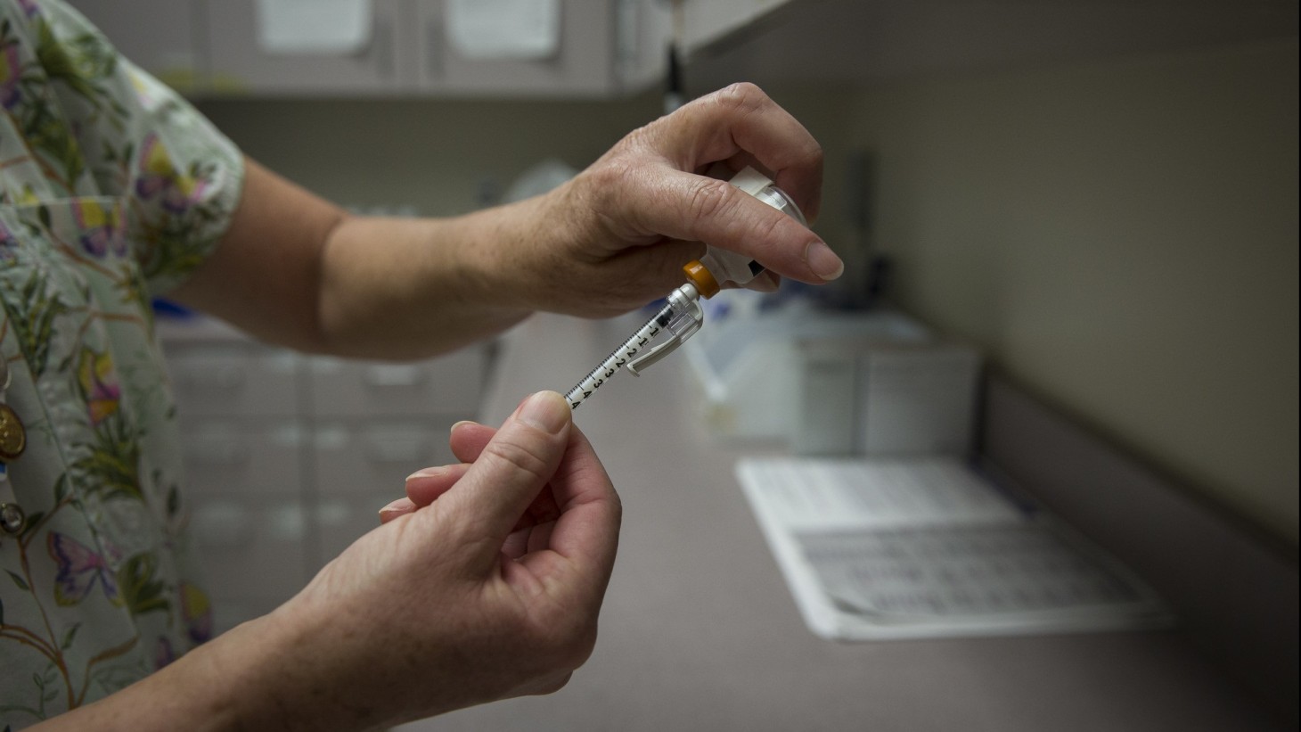 Nurse filling a needle with medication