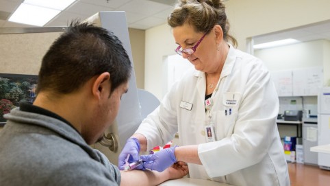 Phlebotomist draws blood.