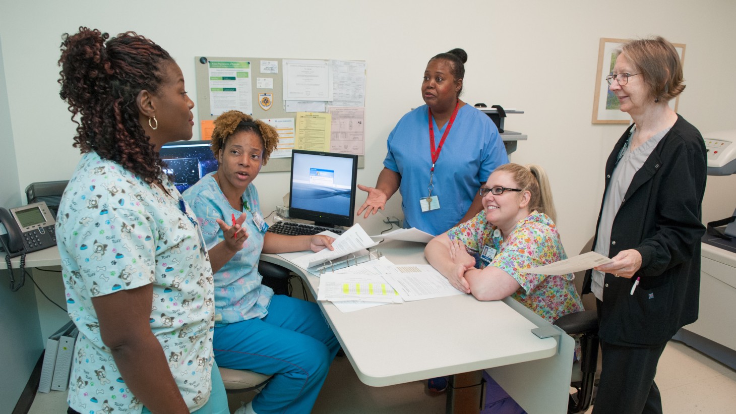 A group of health care workers meeting around a low table 