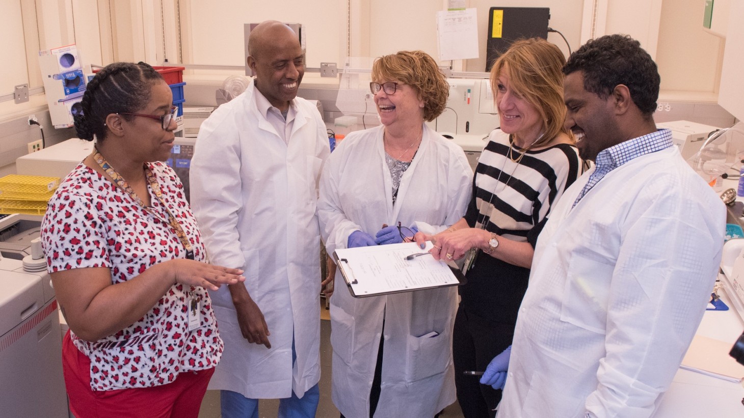 A group of health care workers conferring around a document 