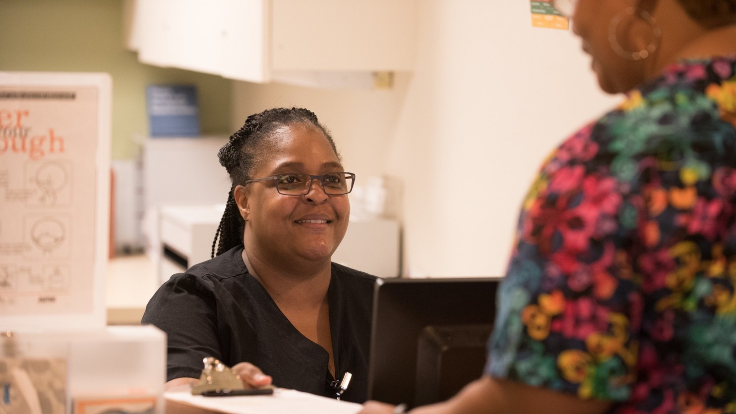 Receptionist checking in a patient for her appointment 