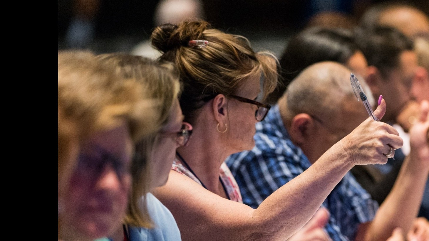 Contract negotiators give their thumbs up on a part of an agreement at a table littered with bottles of water and soda pop.