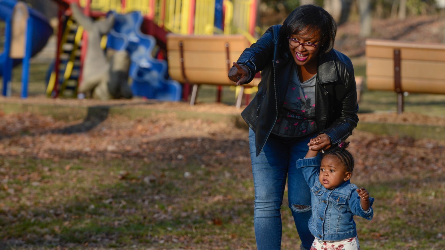 Black mom holding her toddler's hand and pointing